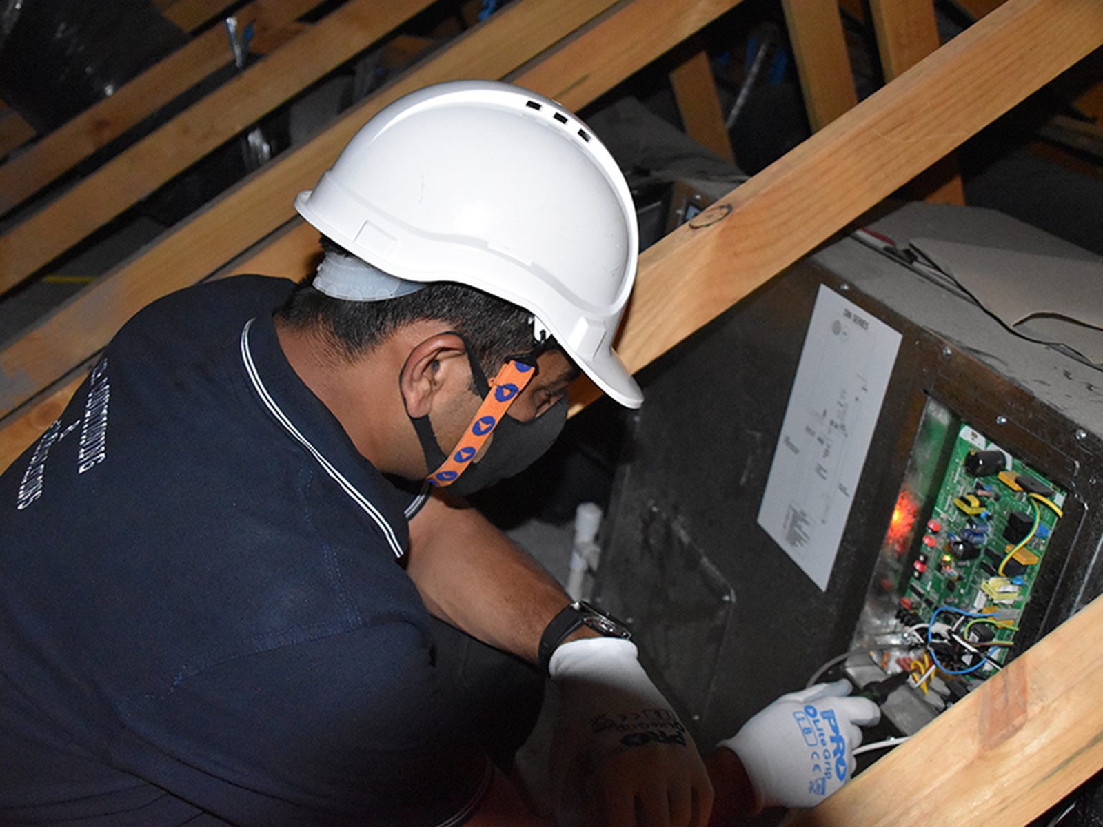 Technician wiring in a roof cavity
